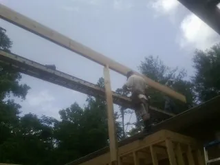 Carpenter setting a ridge beam over a new addition frame — Ice Dam Removal by Roofing Brothers in Craig