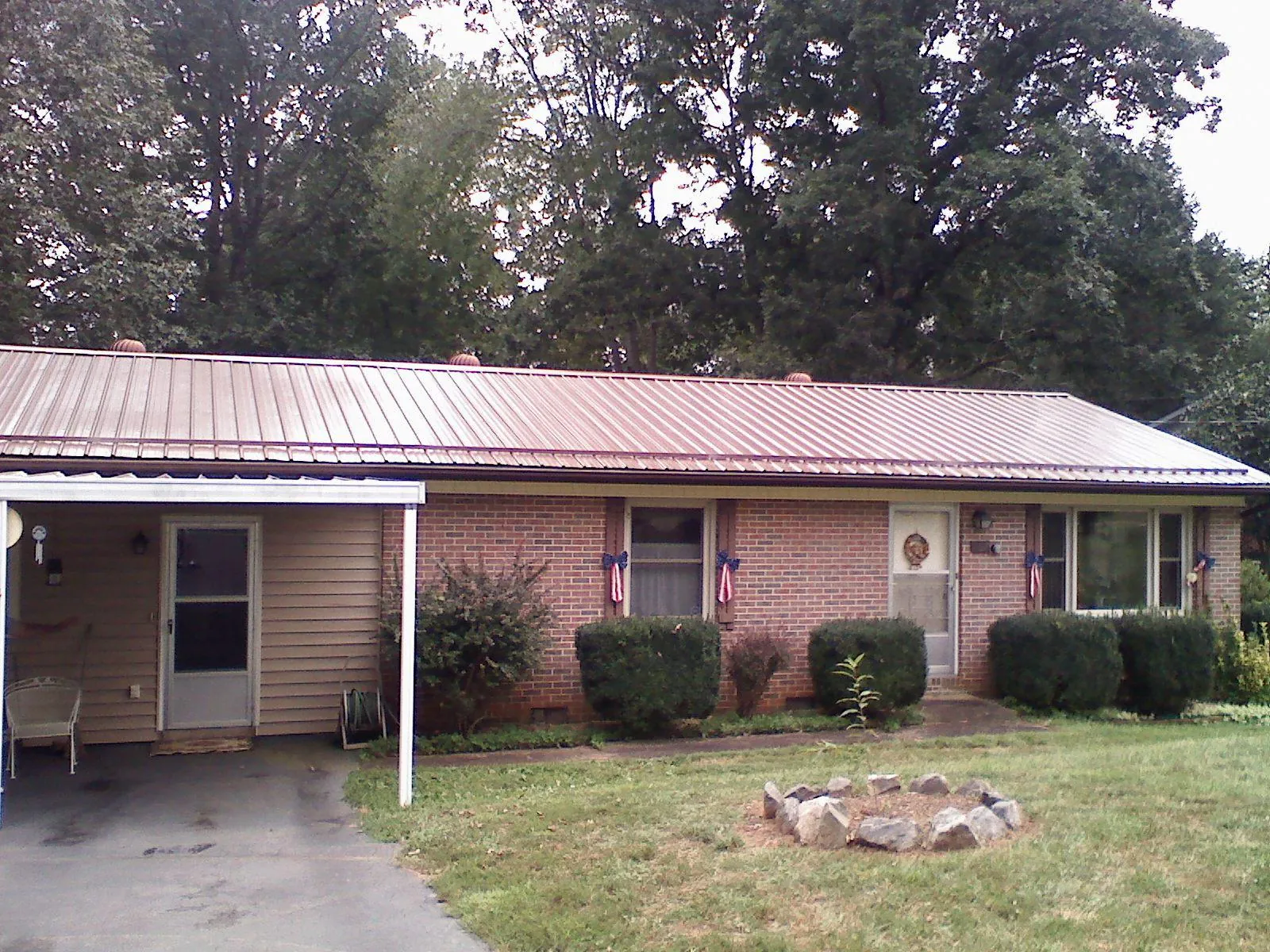 Bronze metal roof and carport on a brick ranch home — Roof Repair work by our crew in Craig